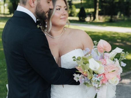 Brautstrauß Strauß aus weißen und lila Blumen, darunter Rosen und Lilien, auf einem Holzuntergrund.